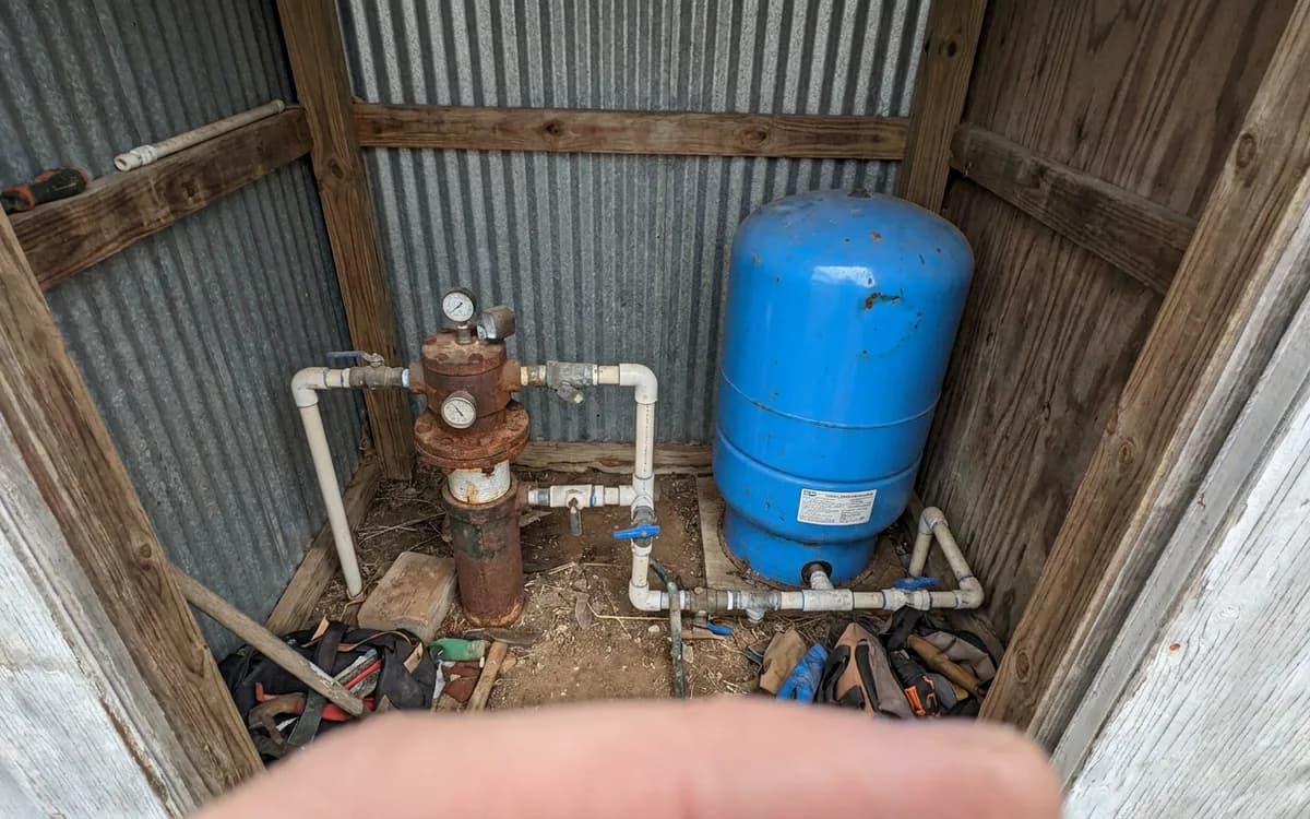Well head and pressure tank in a rural utility enclosure