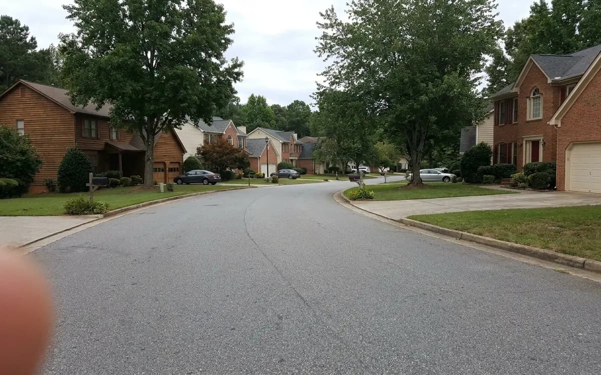 Two-story suburban homes with attached garages on a curving street