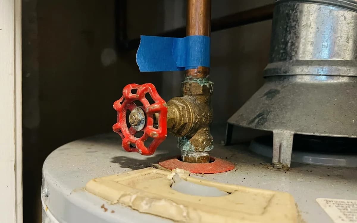 Hand-operated shutoff valve on the cold water line above a water heater