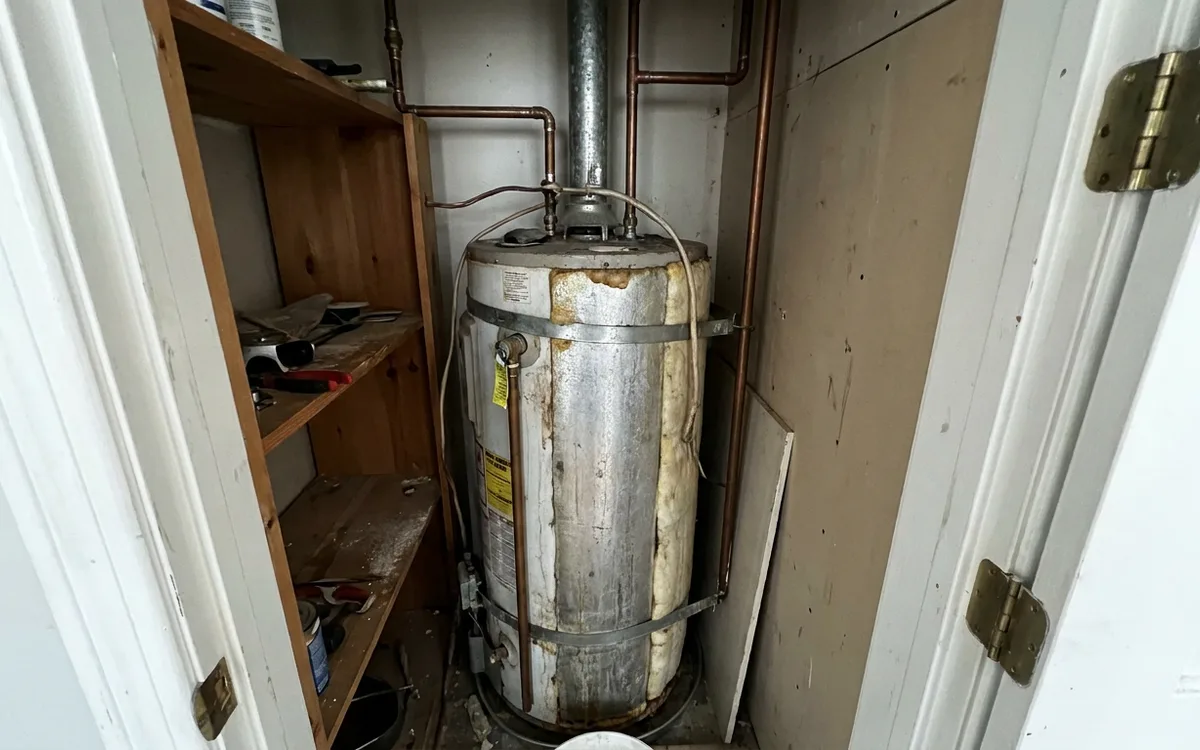 Water heater installed in a narrow interior closet with limited clearance
