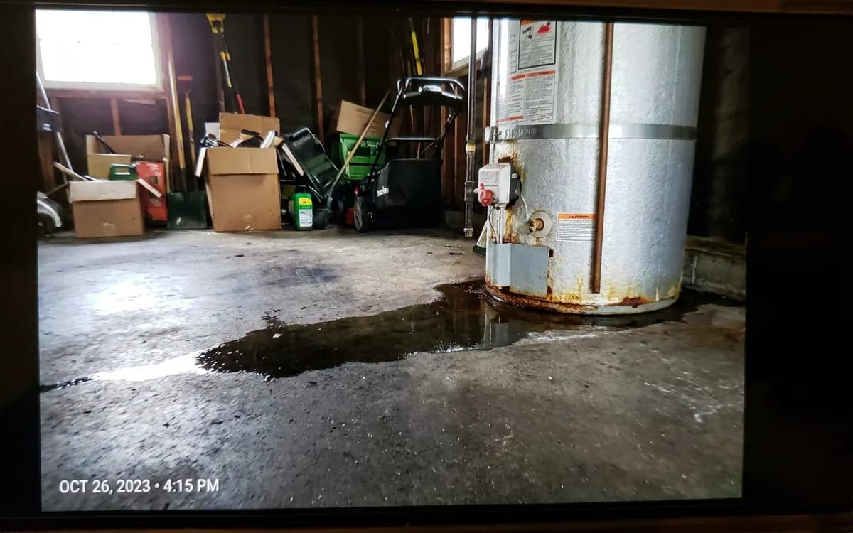 Damp concrete floor beside the base of a water heater
