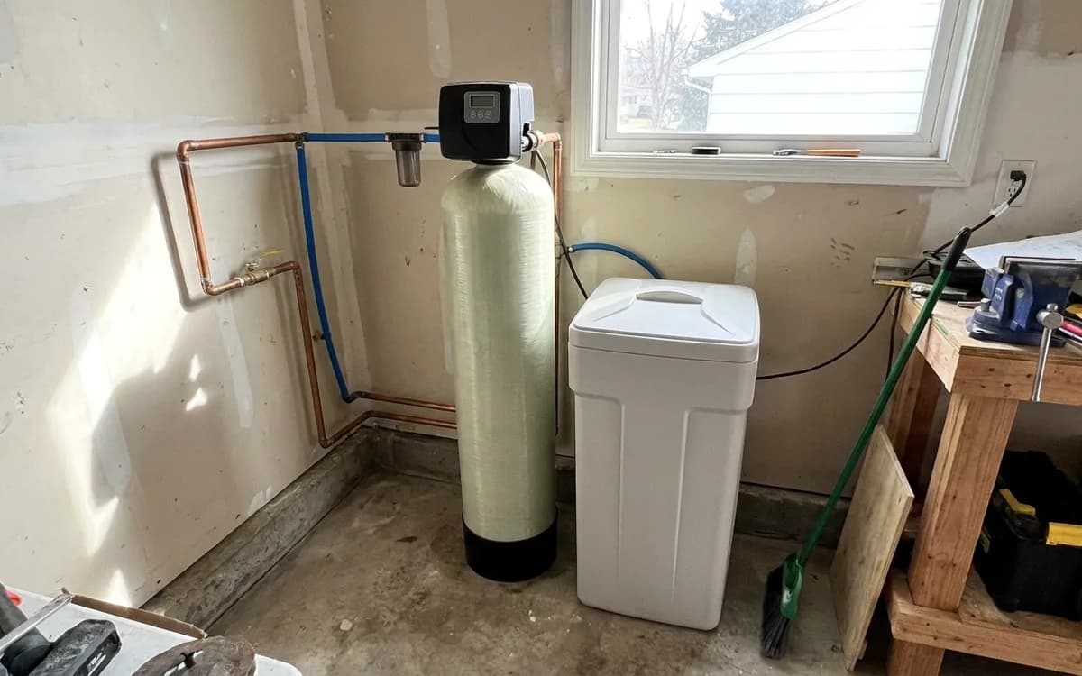 Water softener resin tank and brine tank installed in a garage corner